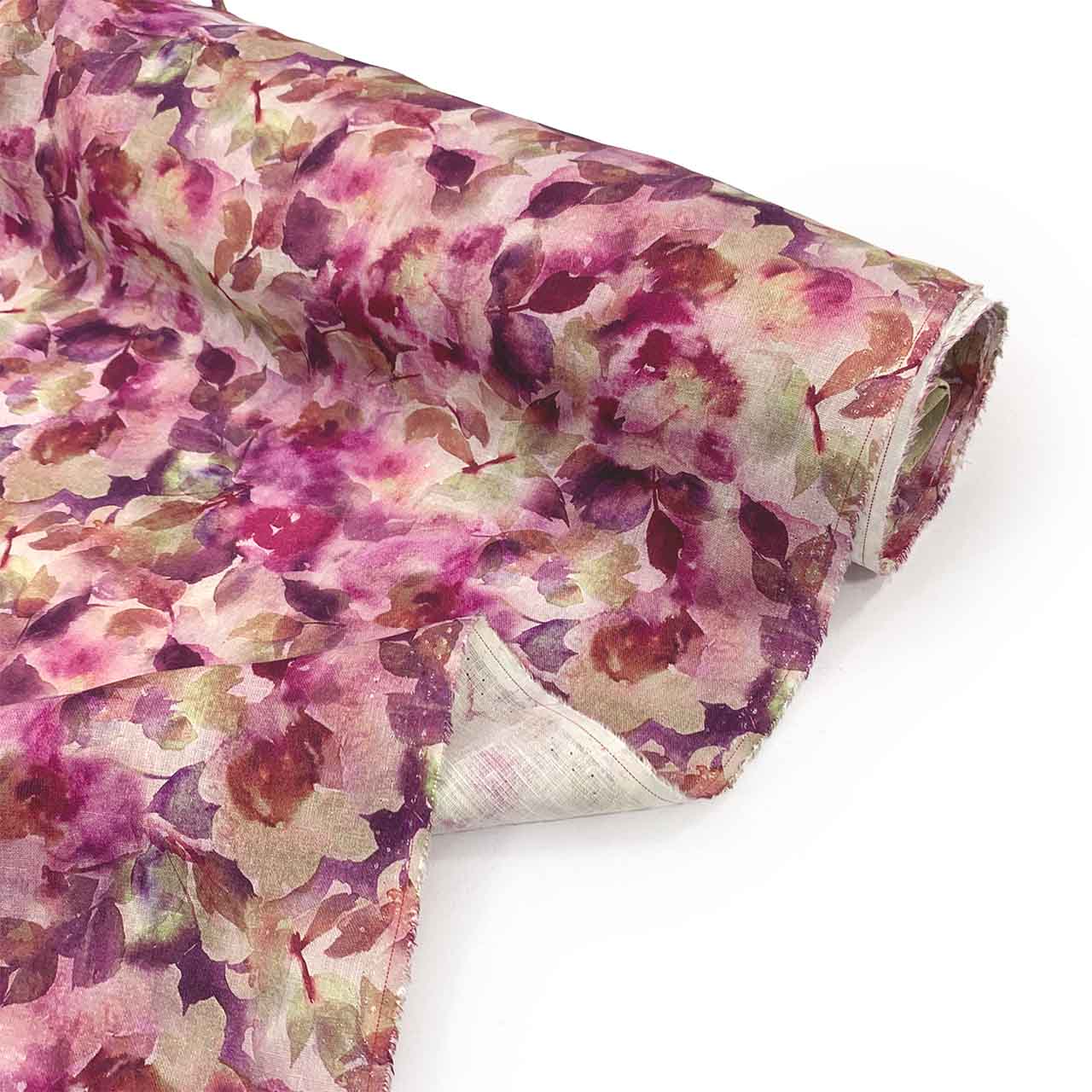 Roll of Vinaccia botanica floral linen fabric with wine hues on a white background - Fabric Collection