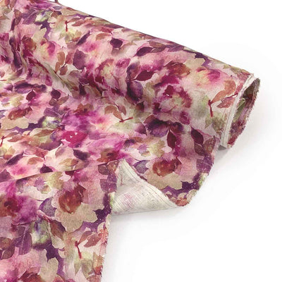 Roll of Vinaccia botanica floral linen fabric with wine hues on a white background - Fabric Collection