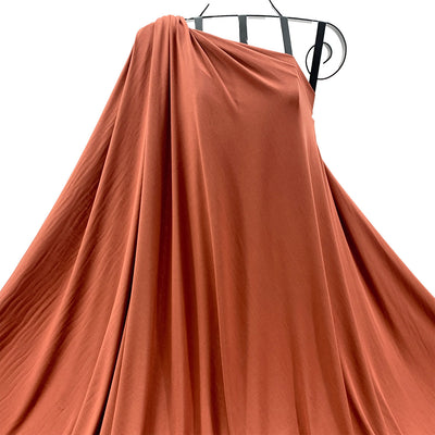 Russet bamboo jersey knit fabric, soft, breathable and draped in front of white background- Fabric Collection