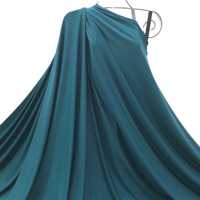 Teal Spruce Green bamboo jersey knit fabric draped as one-shoulder on a mannequin against a white background